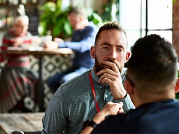 Two men having a thoughtful conversation in a coffee shop