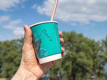 Donate written on a cup held in the sky