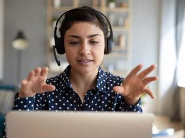 Woman with headset on a call in front of laptop