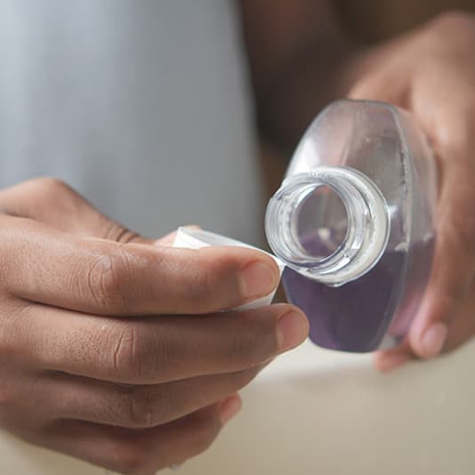 Man pouring mouthwash into the cap