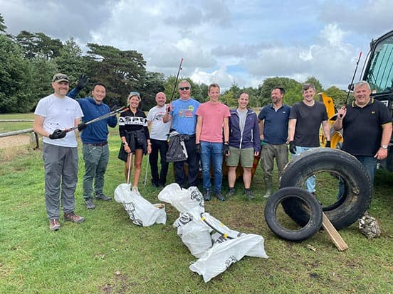 Simplyhealth colleagues stood in a group with litter picking tools