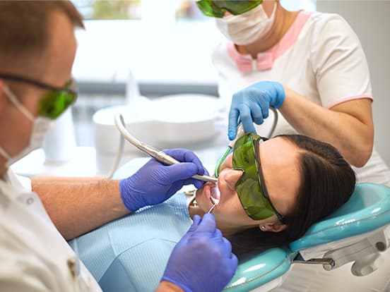 Woman sat in dental chair having teeth looked at