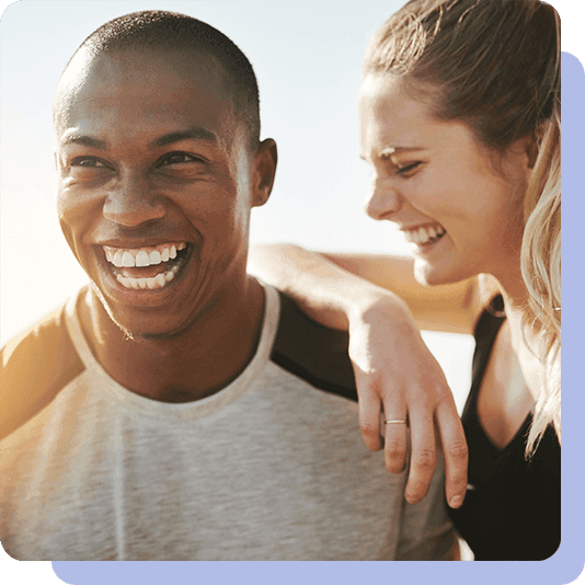 Woman resting her arm on a man's shoulder and both smiling