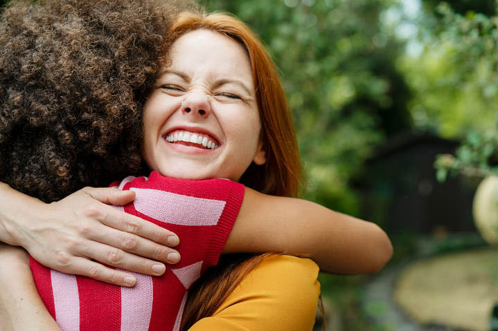 Woman hugging friend and smiling