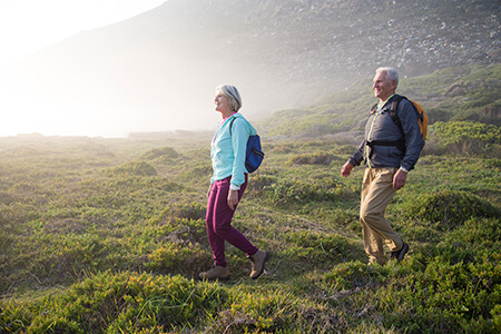 An older couple enjoying a walk down a hillside