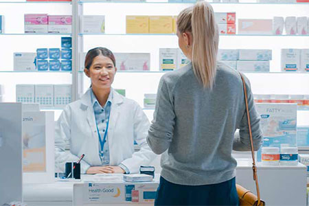 Woman collecting prescription at pharmacy