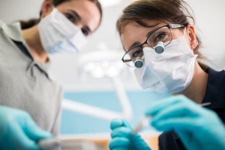 Dentists and nurse examining patient