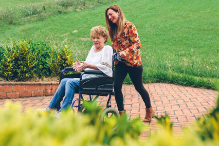Carer pushing her mum in a wheelchair
