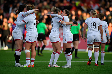 Red Roses players hugging on pitch