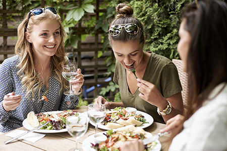 Women enjoying eating healthy food outside
