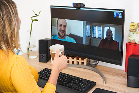 Woman chatting with colleague on video call with a coffee