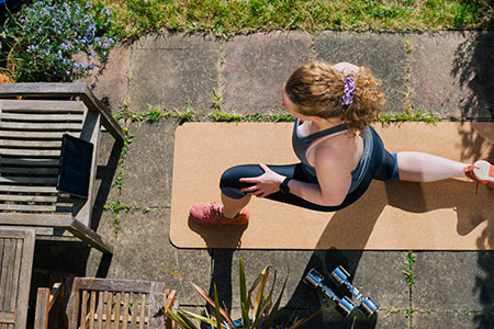 Lady doing yoga in the garden keeping healthy