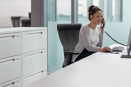 Woman in office on phone at computer