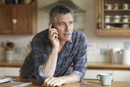 Man taking phone call in kitchen