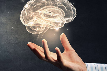 Hand holding an illuminated brain