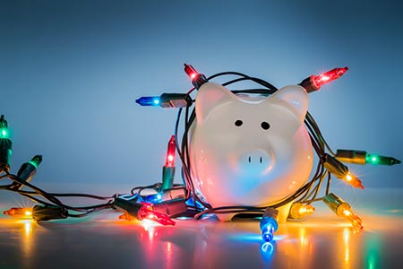 Piggy bank covered in colourful christmas lights