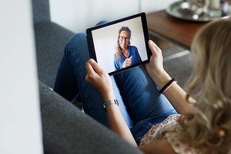 Two women talking to each other via video call on tablet device