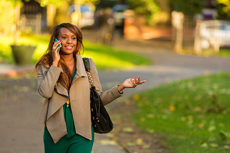 Woman walking and smiling whilst talking on mobile