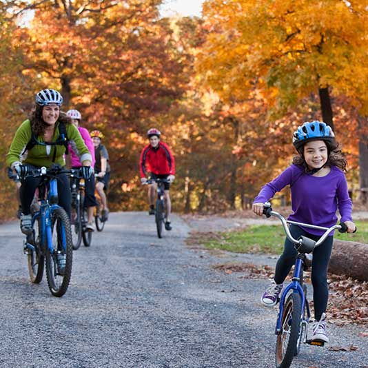 Family cycling through an autumnal park
