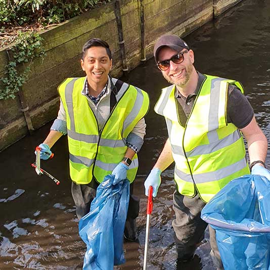 Two Simplyhealth employees picking litter from the river 