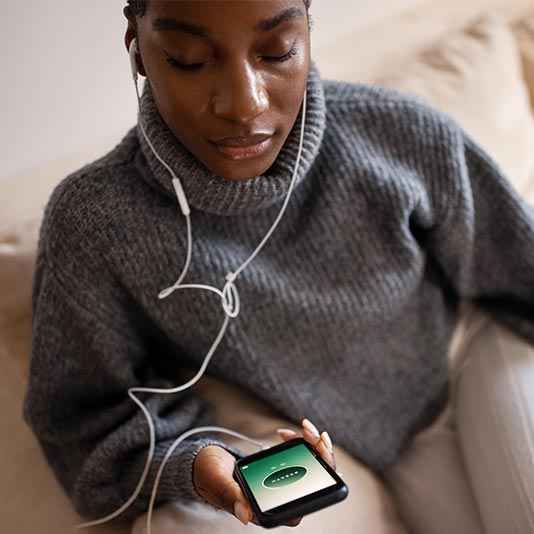 Woman wearing headphones and using a meditation app