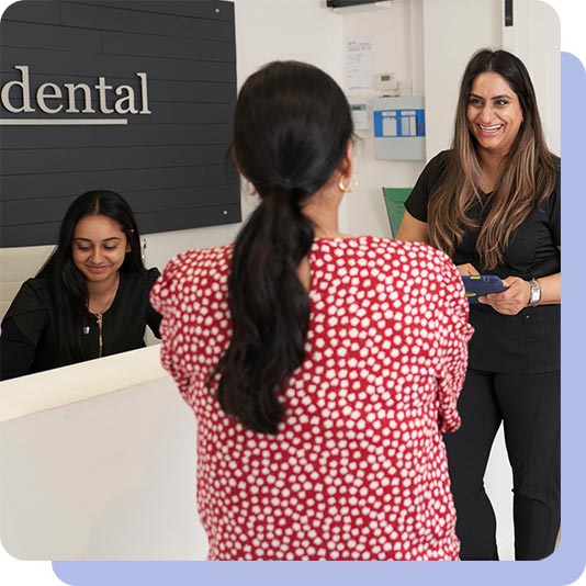 Dentist and patient sharing a joke in the reception area of the dental practice
