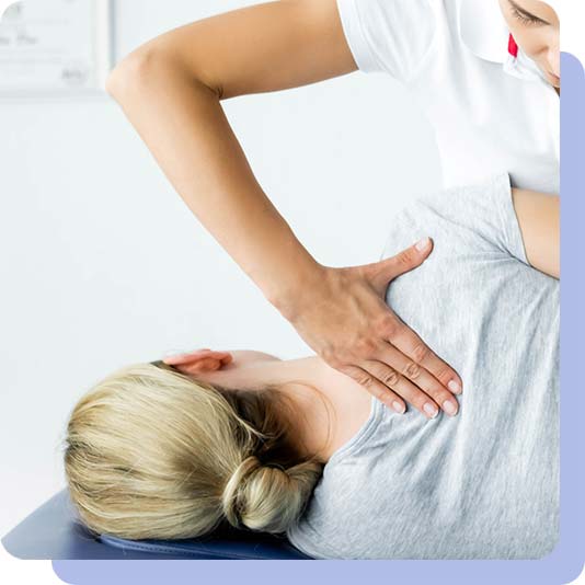 Chiropractor working on a woman's shoulder