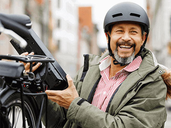 Man holding an electric bike and smiling