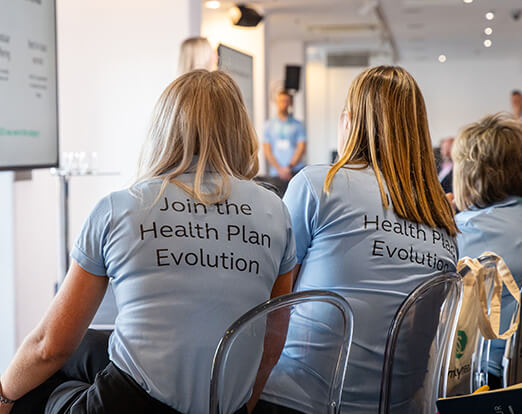 Colleagues wearing Health Plan Evolution t-shirts at broker event