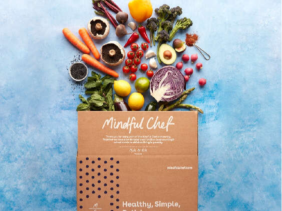 A Mindful Chef box with vegetables pouring out of it
