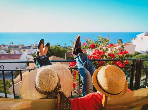 Two people in sun hats relaxing on balcony