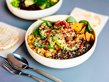 A poke bowl full of vegetables and grains