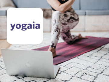 Yogaia logo on image of woman practising yoga in front of laptop