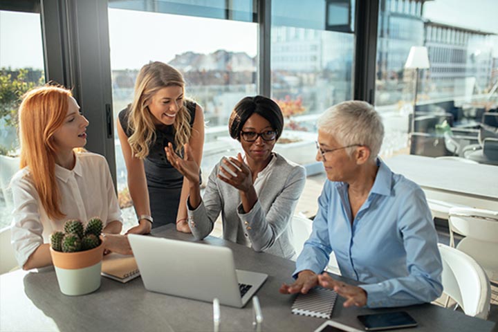 Four women having an open conversation in the office